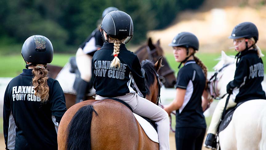 young women riding horses together in a group 