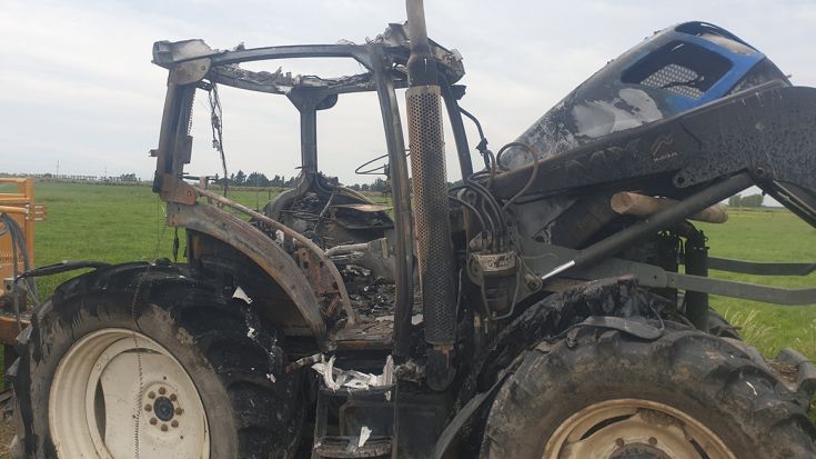 badly damaged tractor burnt out after a fire 