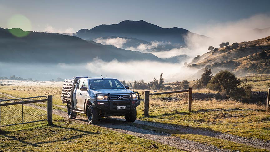 ute driving through open gate on farm 