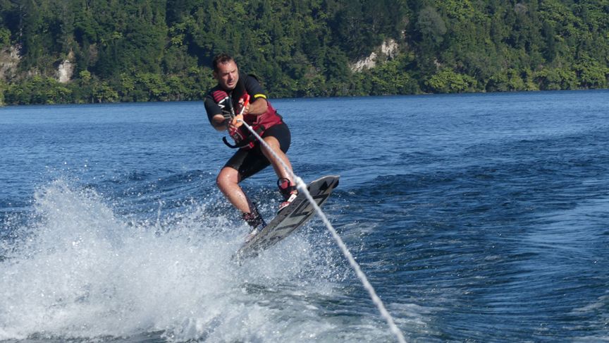 man in lifejacket wakeboarding