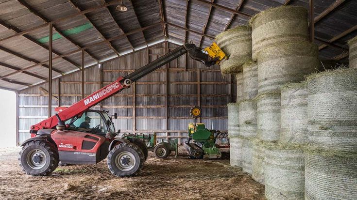 front end loader stacking bales of hay 