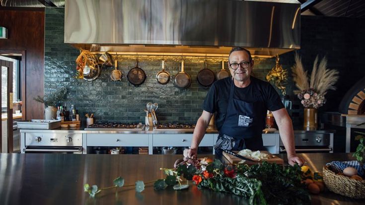 Michael van de Elzen standing by kitchen benchtop with fresh vegetables in front of him 