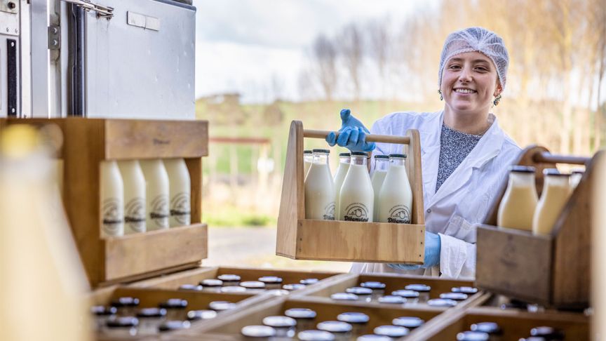 Girl holding up milk bottles