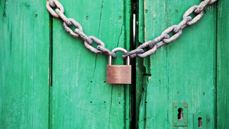 chain and padlock on a green shed door 
