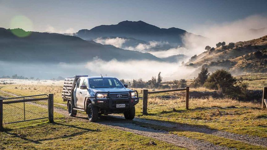 Ute driving through gate in paddock 