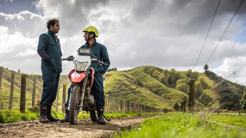 two farmers talking one on motorbike