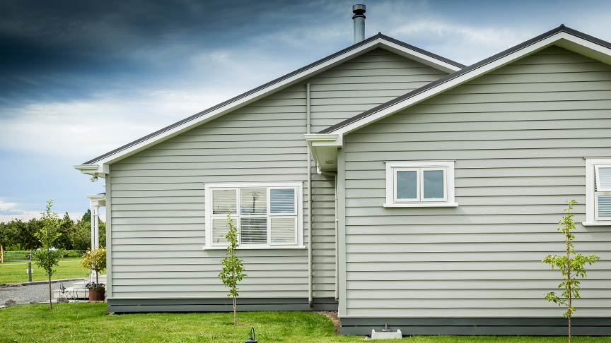 side view of a light brown weatherboard house 