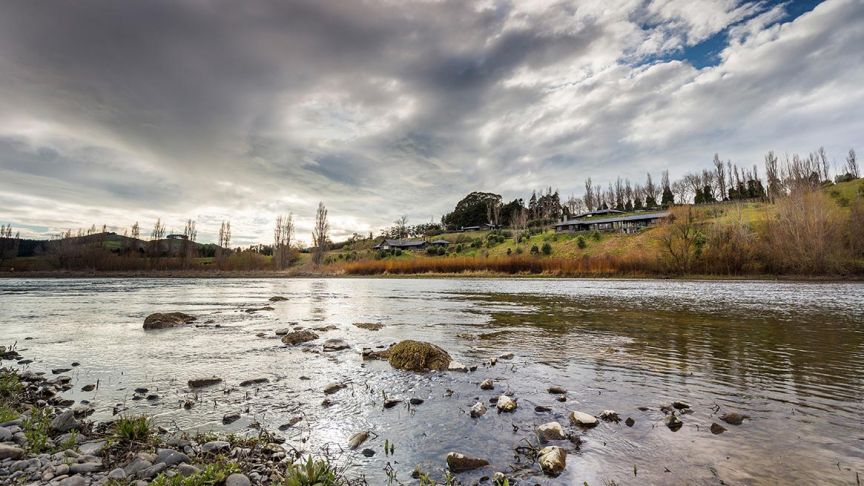 river bed with houses on bank in background 