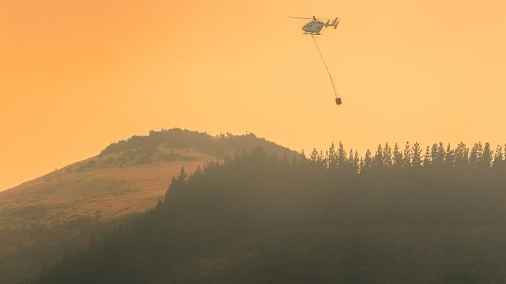 helicopter dropping water on rural fire 