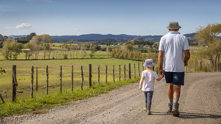 grandfather walking with granddaughter wearing bucket hats 