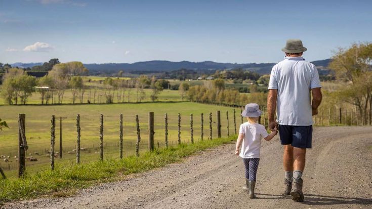 grandfather walking with granddaughter wearing bucket hats 