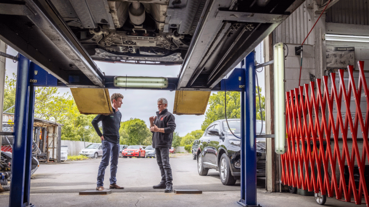 Two men talking in a mechanics garage
