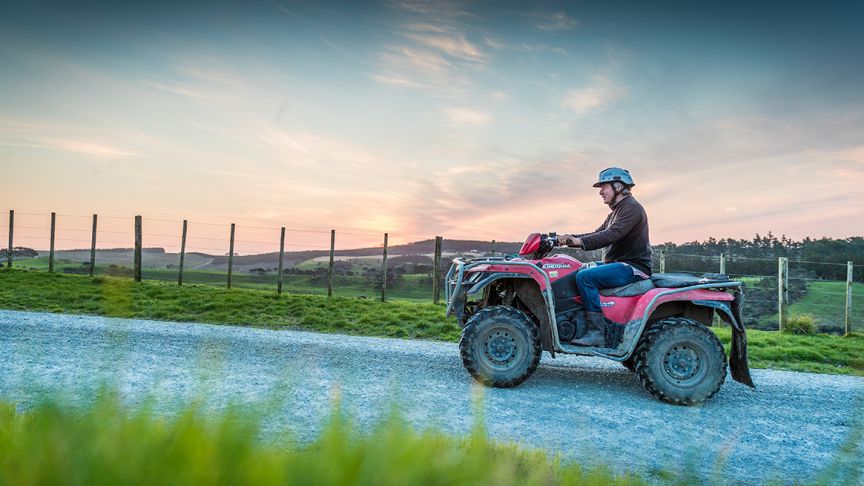 Man riding quad bike on road 